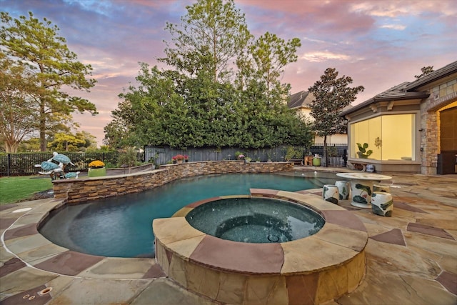 pool at dusk with an in ground hot tub