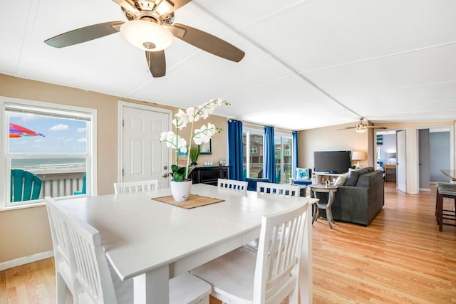 dining space with light wood-style flooring and baseboards