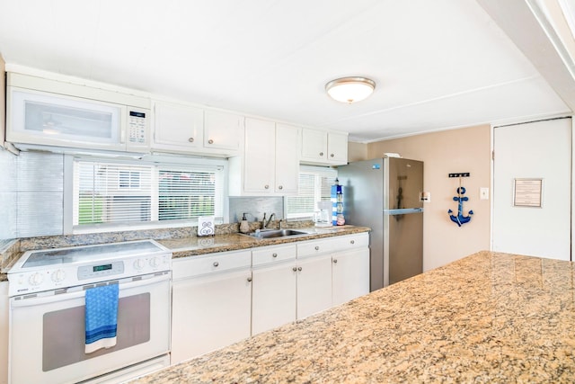 kitchen featuring sink, white cabinets, and white appliances