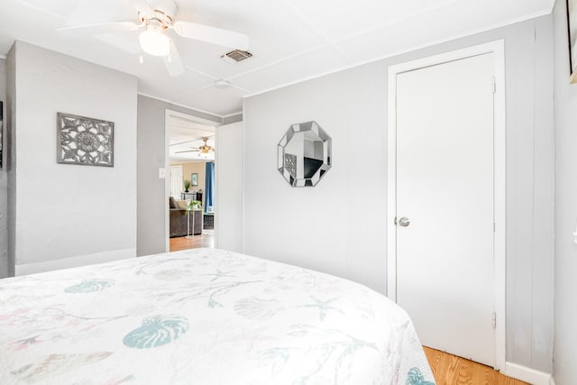 bedroom with visible vents, a ceiling fan, and wood finished floors