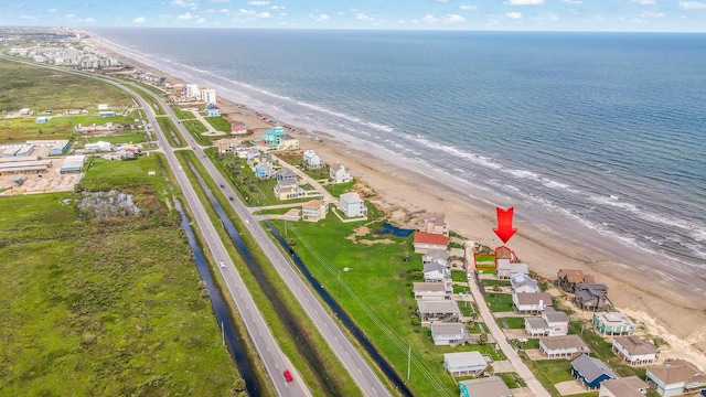 drone / aerial view featuring a water view and a beach view