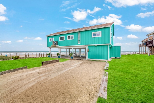 view of front of property featuring a front yard, a carport, and a water view