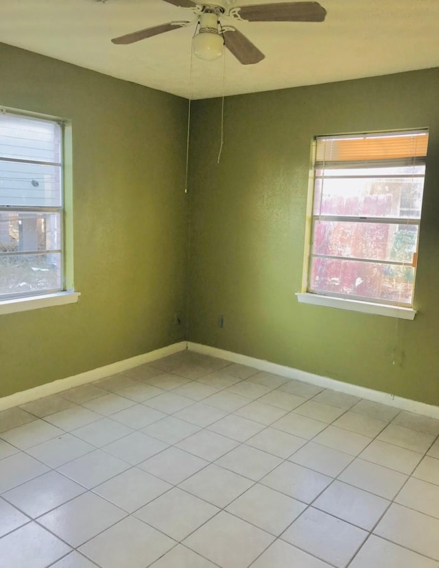 tiled spare room with ceiling fan