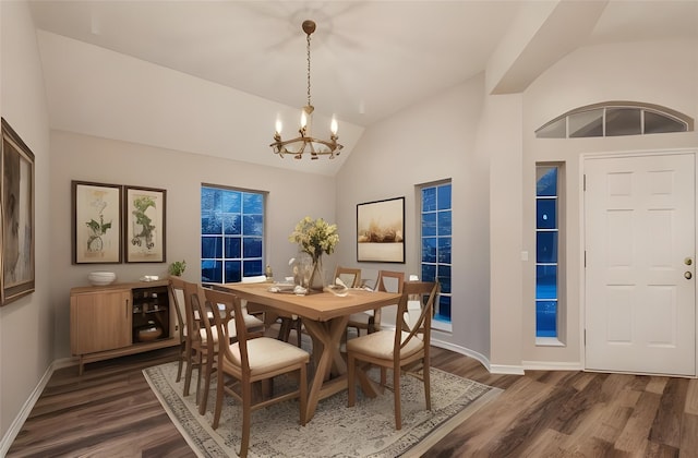 dining room featuring a chandelier, high vaulted ceiling, and dark wood-type flooring