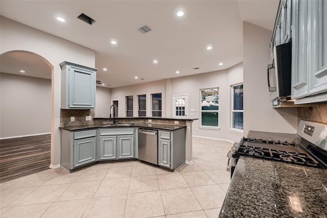 kitchen with gray cabinetry, sink, light tile patterned floors, kitchen peninsula, and stainless steel appliances