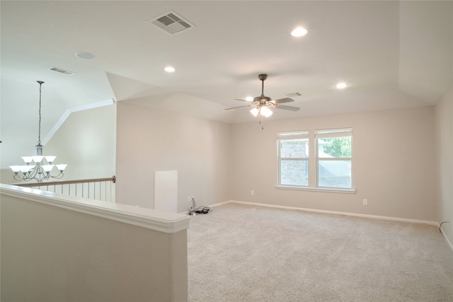 carpeted spare room featuring lofted ceiling and ceiling fan with notable chandelier