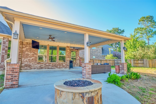 view of patio / terrace with ceiling fan and an outdoor living space with a fire pit