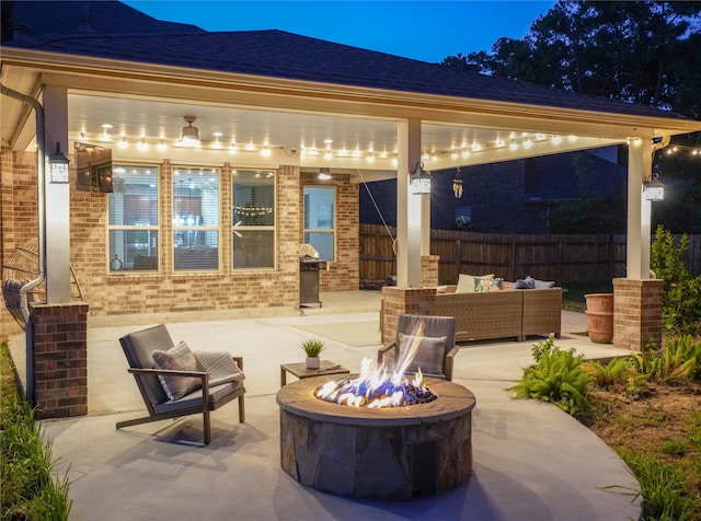 view of patio / terrace featuring ceiling fan and an outdoor living space with a fire pit