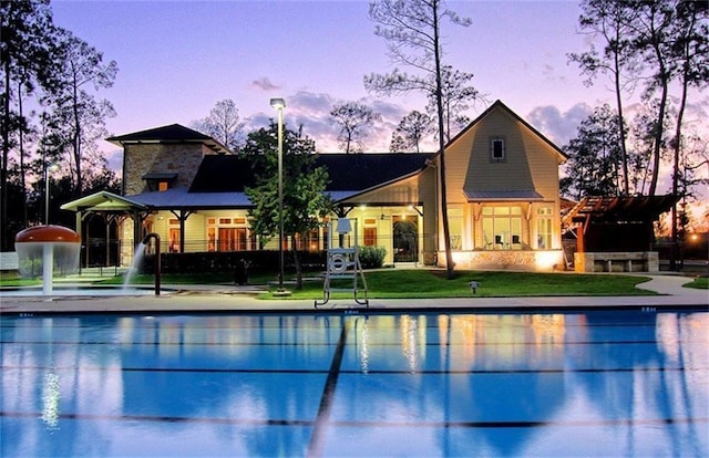 pool at dusk with a grill and a yard