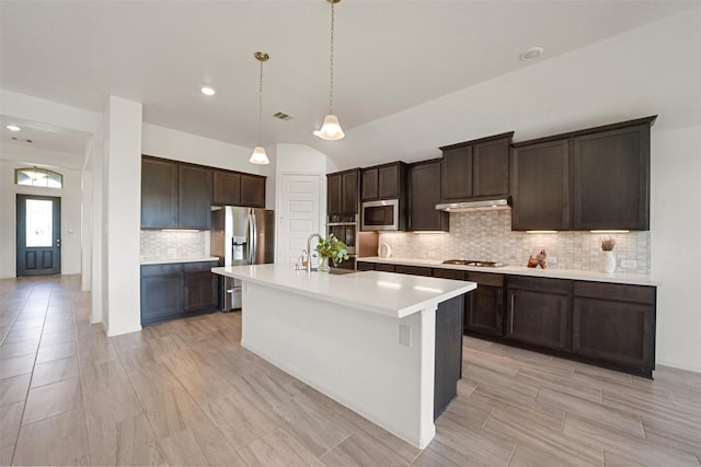 kitchen featuring sink, a kitchen island with sink, decorative backsplash, dark brown cabinets, and appliances with stainless steel finishes