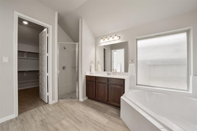 bathroom featuring lofted ceiling, vanity, and independent shower and bath