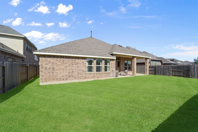 rear view of property featuring a lawn and a patio