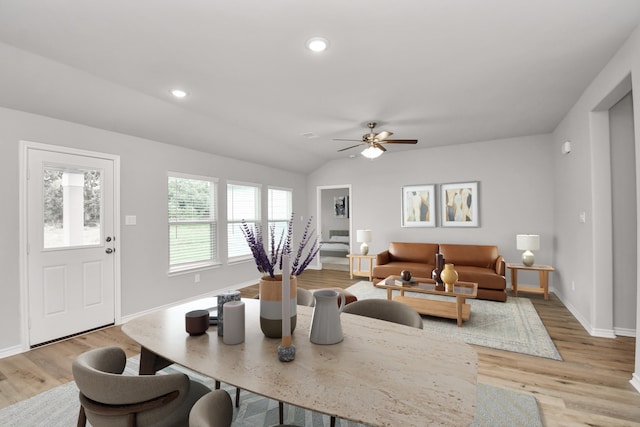 dining room featuring ceiling fan, light wood-type flooring, and vaulted ceiling