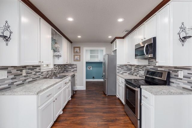 kitchen featuring sink, tasteful backsplash, dark hardwood / wood-style flooring, white cabinets, and appliances with stainless steel finishes