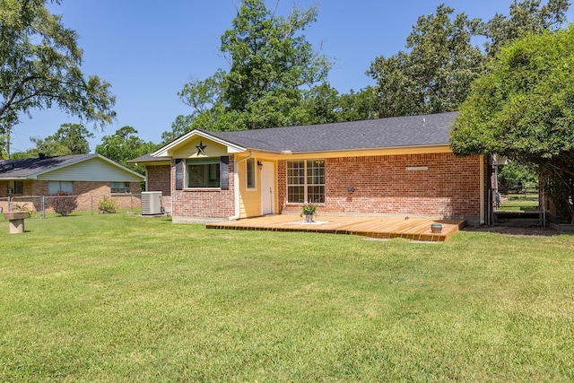 view of front of home with central AC, a front yard, and a deck