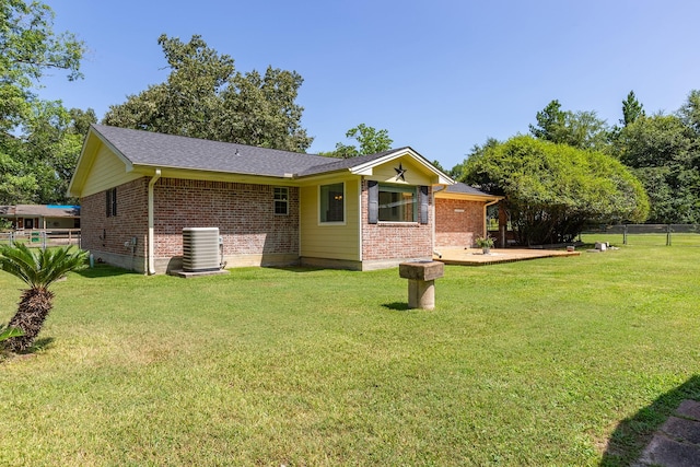 back of house featuring a yard and central AC