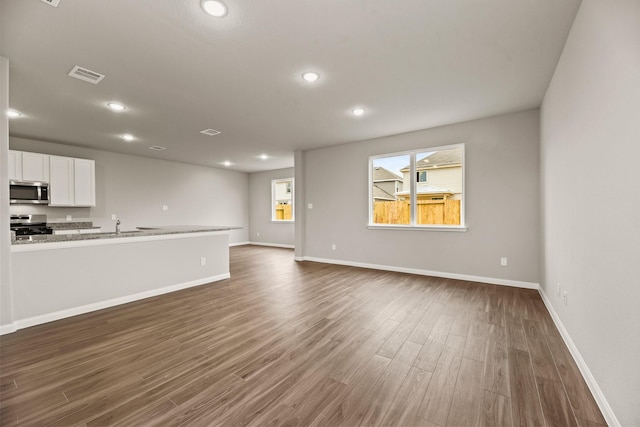 unfurnished living room with dark wood-type flooring