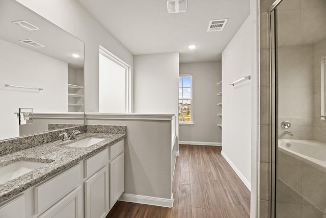 bathroom featuring hardwood / wood-style floors, vanity, and a shower with shower door