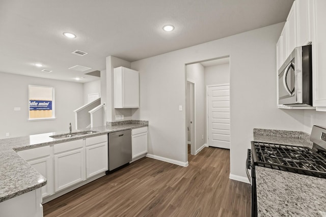 kitchen featuring light stone counters, sink, white cabinetry, and stainless steel appliances