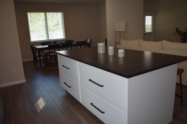 kitchen featuring a kitchen island, white cabinetry, and dark wood-type flooring