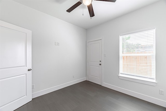 empty room with ceiling fan and dark hardwood / wood-style flooring