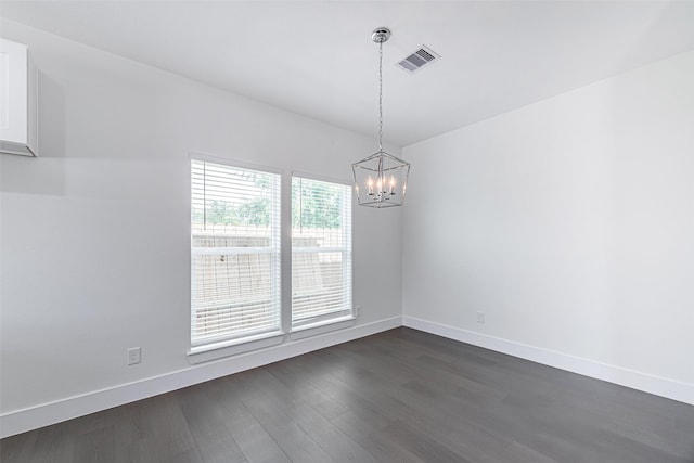 unfurnished dining area featuring dark hardwood / wood-style floors and an inviting chandelier