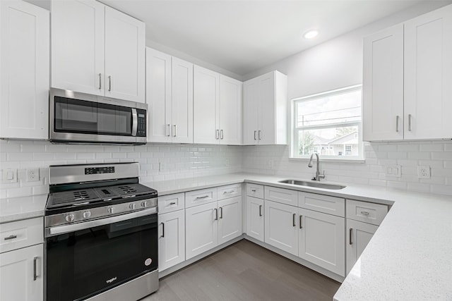 8211 Gladstone St, Houston, TX 77051 - kitchen with stainless steel appliances, white cabinetry, wood finished floors, tasteful backsplash, and recessed lighting