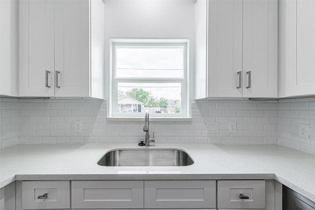 8211 Gladstone St, Houston, TX 77051 - kitchen with white cabinets, backsplash, and light stone countertops