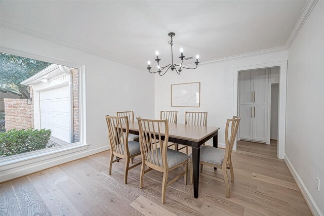 dining space with light hardwood / wood-style flooring, an inviting chandelier, and crown molding