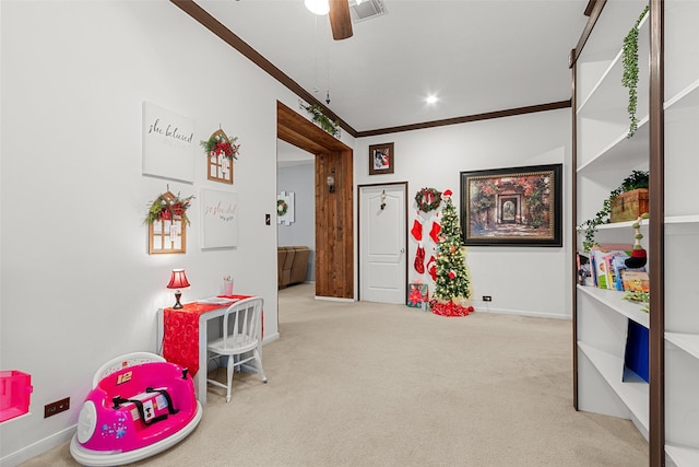 playroom with light carpet, ceiling fan, and crown molding