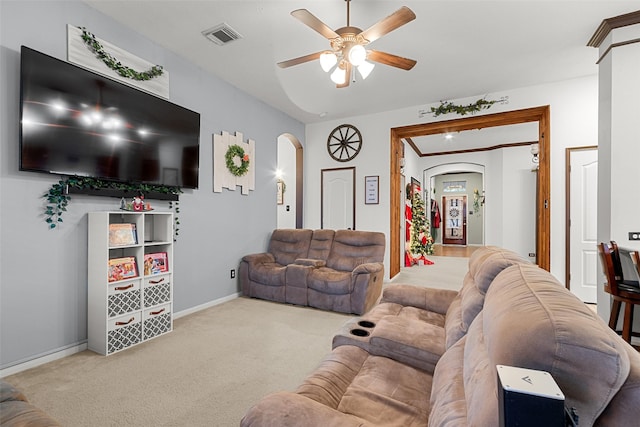 carpeted living room featuring ceiling fan and ornamental molding