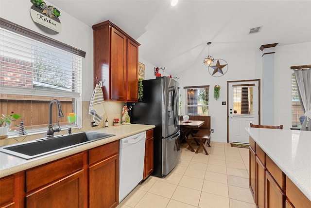 kitchen with a wealth of natural light, dishwasher, sink, and vaulted ceiling