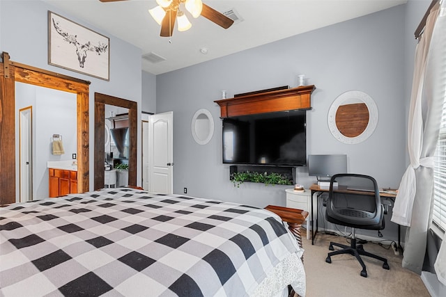 bedroom with light carpet, ensuite bathroom, and ceiling fan