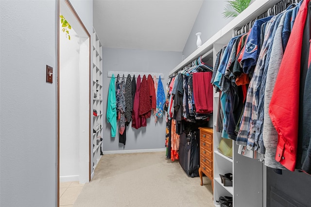 spacious closet featuring light colored carpet and lofted ceiling