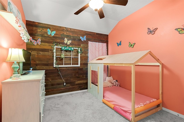 carpeted bedroom with wooden walls, ceiling fan, and lofted ceiling