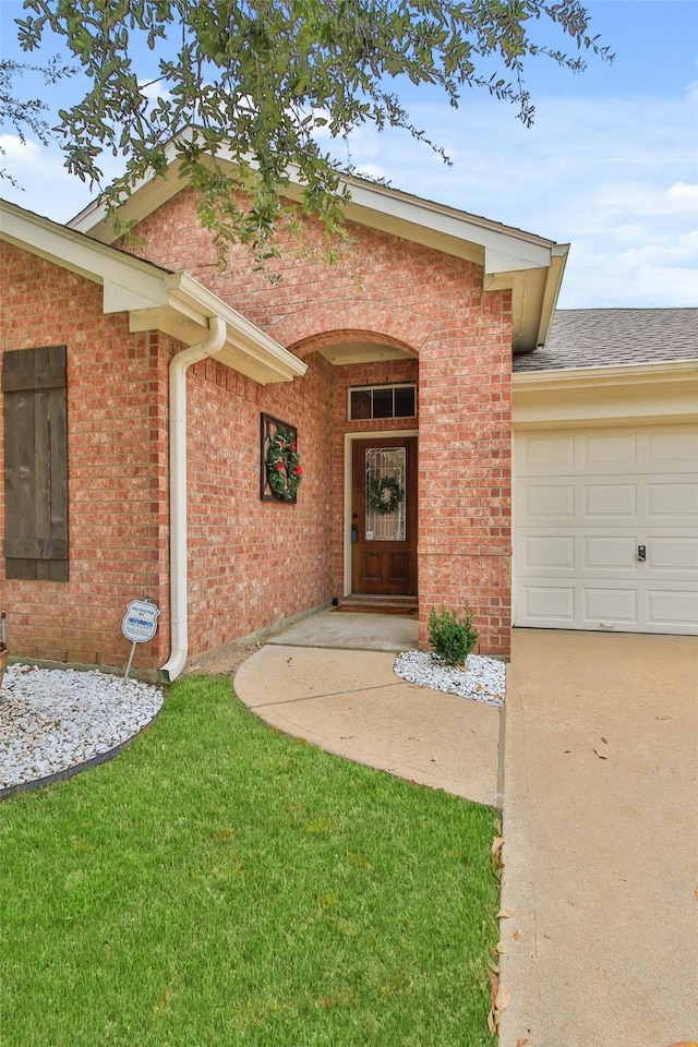 property entrance with a lawn and a garage