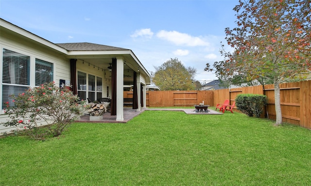 view of yard with ceiling fan, a patio, and a fire pit