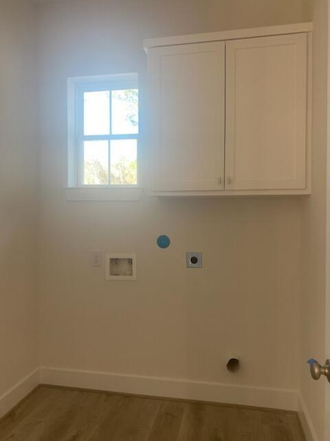 washroom featuring washer hookup, electric dryer hookup, cabinets, and hardwood / wood-style flooring