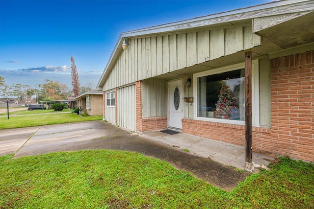 2007 Flynn Dr, Pasadena, TX 77502 - entrance to property featuring brick siding, a yard, and board and batten siding