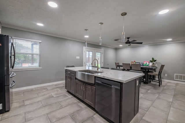 kitchen featuring black fridge, stainless steel dishwasher, ceiling fan, sink, and an island with sink