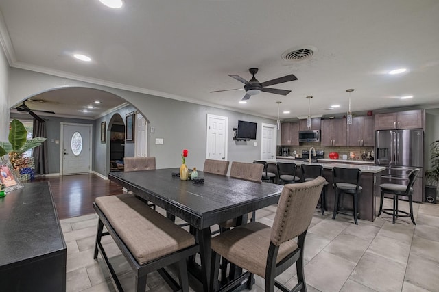 dining area with crown molding and ceiling fan