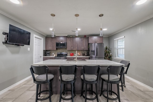 2007 Flynn Dr, Pasadena, TX 77502 - kitchen featuring stainless steel appliances, a sink, crown molding, decorative backsplash, and dark brown cabinets