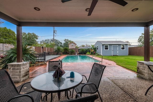 view of pool featuring a lawn, a patio area, and an outbuilding