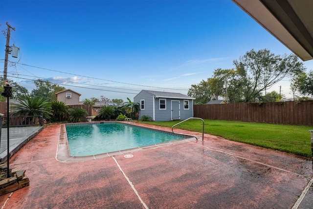 view of pool featuring a patio area, an outdoor structure, and a lawn