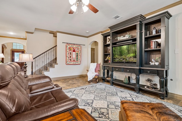 living room featuring built in shelves, ceiling fan, and crown molding