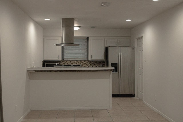 kitchen featuring stainless steel refrigerator with ice dispenser, white cabinetry, tasteful backsplash, island range hood, and kitchen peninsula