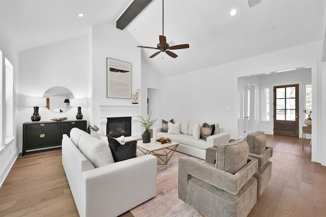 living room featuring ceiling fan, beamed ceiling, high vaulted ceiling, and light wood-type flooring