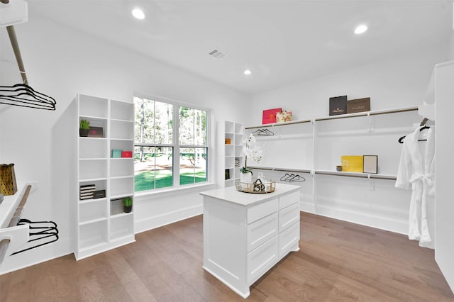 walk in closet with hardwood / wood-style floors