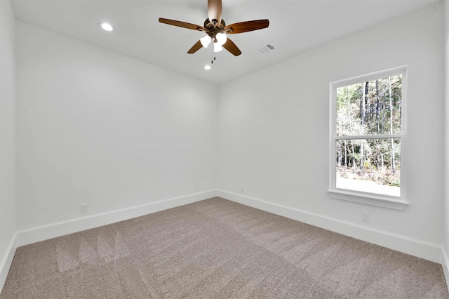 carpeted spare room with ceiling fan