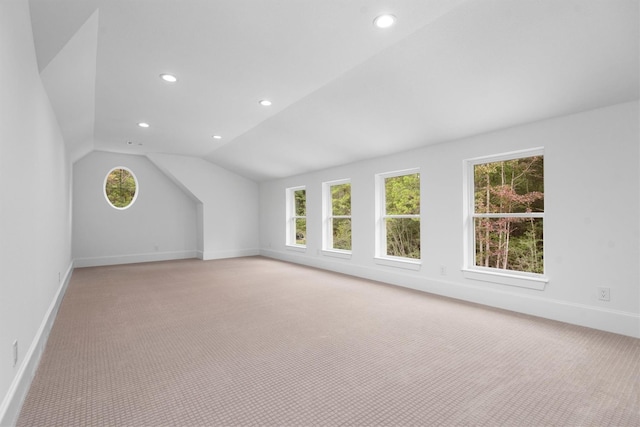 bonus room featuring light carpet and vaulted ceiling